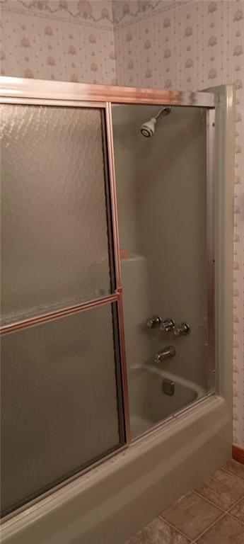 bathroom featuring tile patterned floors and bath / shower combo with glass door