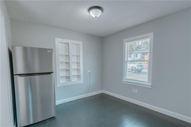 spare room featuring built in shelves and a textured ceiling