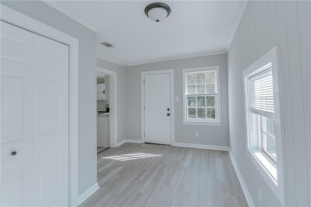 foyer entrance featuring ornamental molding and light hardwood / wood-style flooring