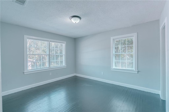 empty room featuring dark hardwood / wood-style floors and a textured ceiling