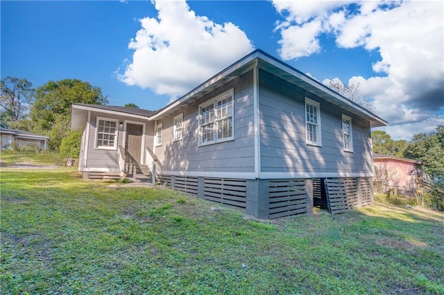 view of side of home with a yard