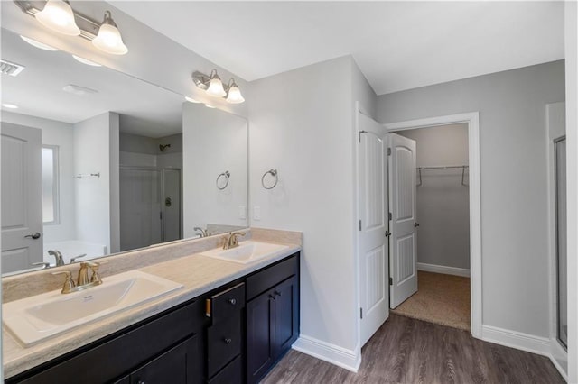 bathroom featuring wood-type flooring, a shower with door, and vanity