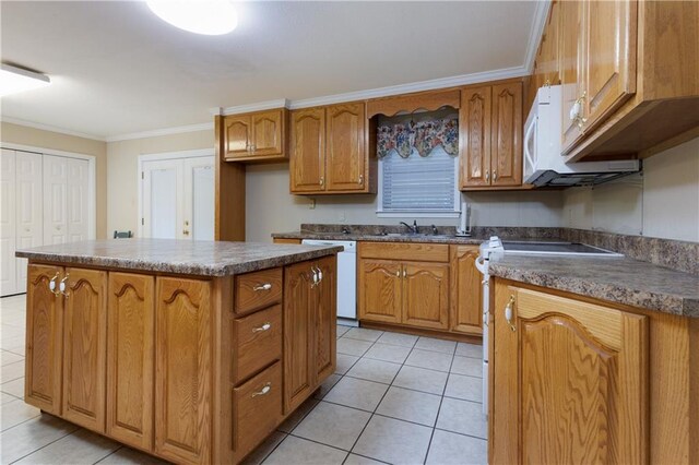 kitchen with white appliances, sink, light tile patterned floors, crown molding, and a center island