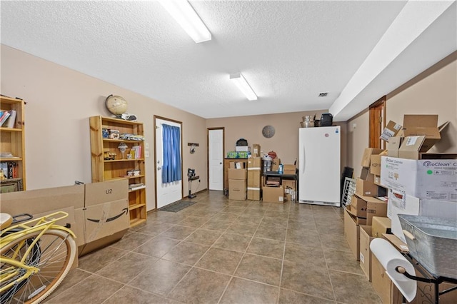 misc room featuring tile patterned floors and a textured ceiling