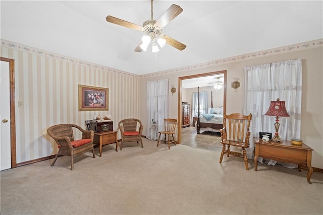 living area featuring light carpet and ceiling fan