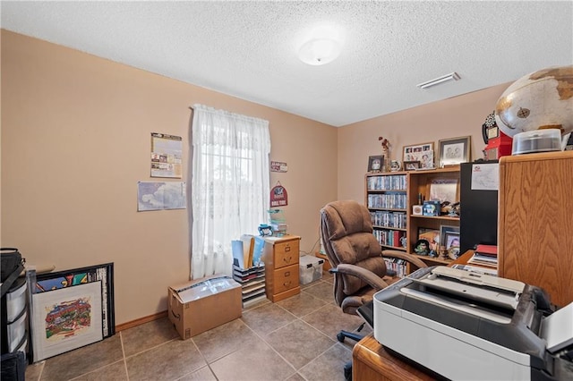 office area with light tile patterned floors and a textured ceiling