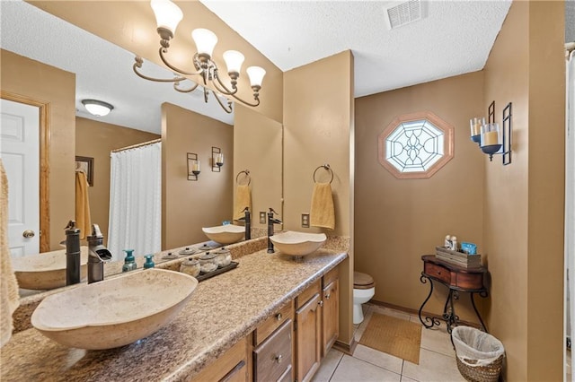 bathroom featuring a textured ceiling, tile patterned floors, vanity, an inviting chandelier, and toilet