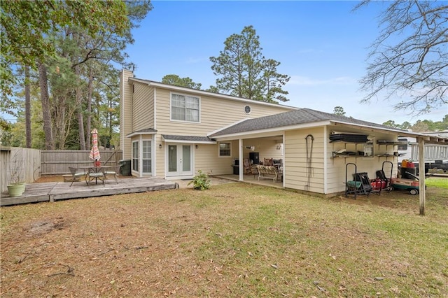 back of house featuring a wooden deck, french doors, and a yard