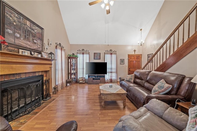 living room featuring light hardwood / wood-style floors, high vaulted ceiling, and ceiling fan