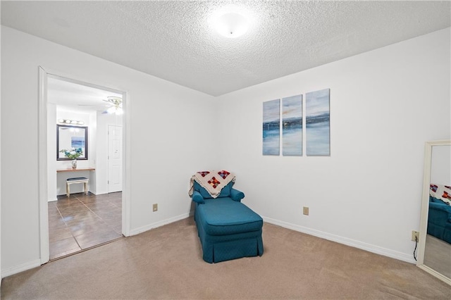 sitting room with ceiling fan, tile patterned flooring, and a textured ceiling