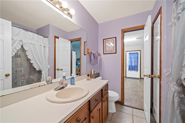 bathroom with toilet, vanity, and tile patterned floors