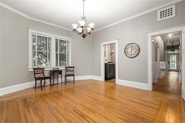 13 Demouy Ave, Mobile, AL 36606 - dining room featuring crown molding, hardwood / wood-style flooring, baseboards, a chandelier, and washer / clothes dryer