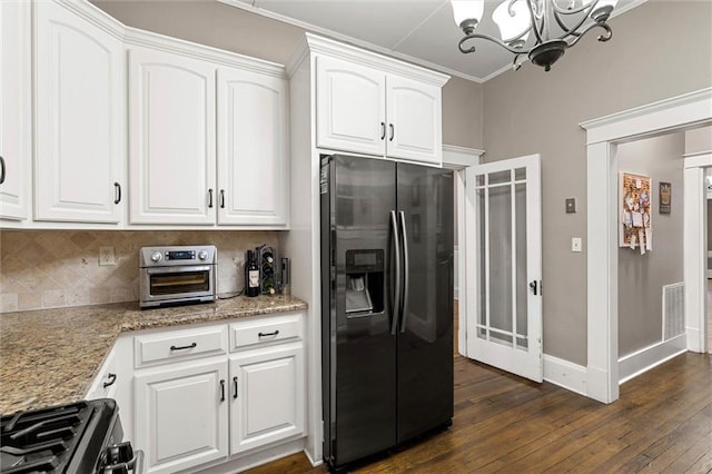 13 Demouy Ave, Mobile, AL 36606 - kitchen with stainless steel appliances, a chandelier, dark wood-type flooring, white cabinets, and light stone counters