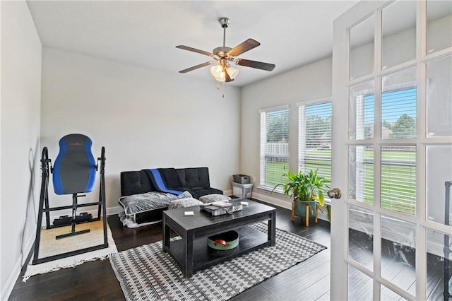 living room featuring ceiling fan and dark hardwood / wood-style flooring