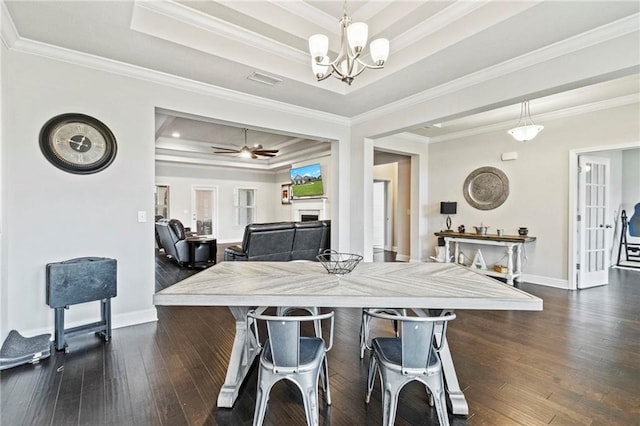 dining space with a tray ceiling, crown molding, ceiling fan with notable chandelier, and dark hardwood / wood-style floors