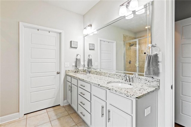 bathroom featuring a shower with door, vanity, and tile patterned floors