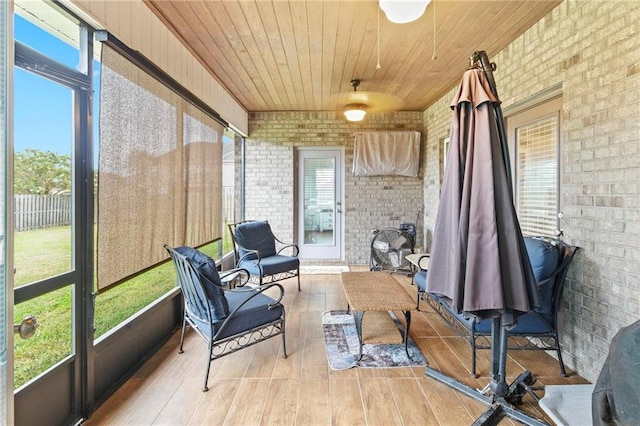 sunroom / solarium with a healthy amount of sunlight and wooden ceiling