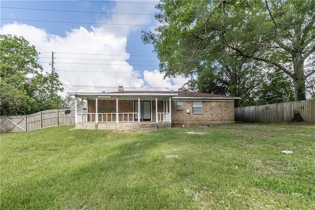 back of property featuring a lawn, a fenced backyard, brick siding, and a sunroom