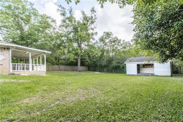 view of yard with fence and an outbuilding