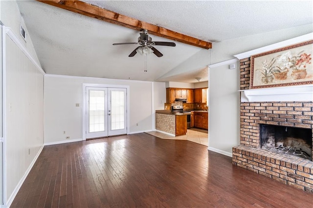unfurnished living room featuring lofted ceiling with beams, a ceiling fan, a fireplace, and wood-type flooring