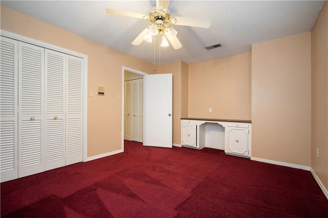 504 Vaughan Dr N, Satsuma, AL 36572 - unfurnished bedroom with dark carpet, baseboards, a closet, and a ceiling fan