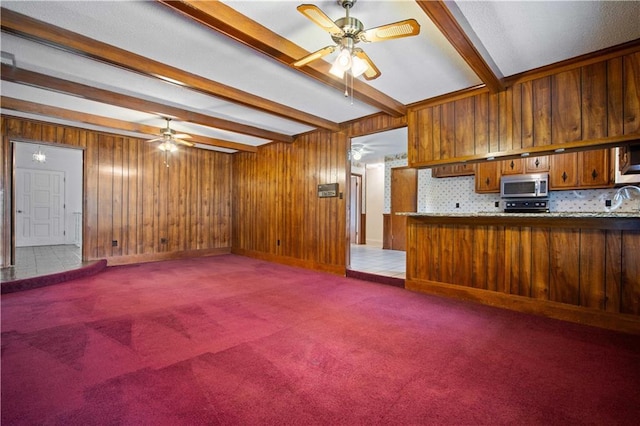 504 Vaughan Dr N, Satsuma, AL 36572 - unfurnished living room featuring a ceiling fan, beam ceiling, carpet, and wooden walls