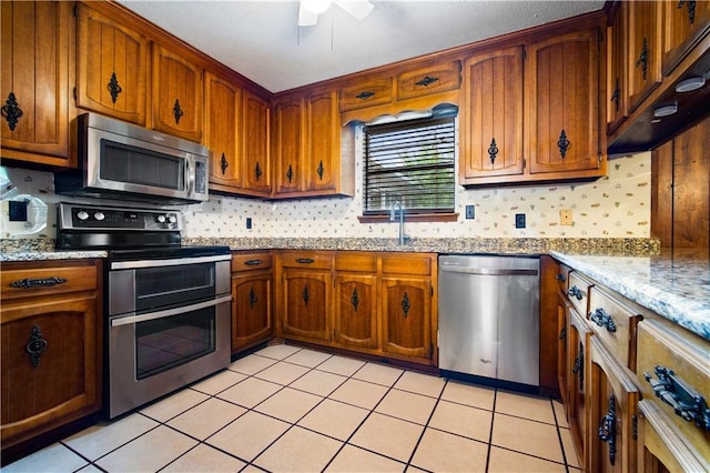 504 Vaughan Dr N, Satsuma, AL 36572 - kitchen featuring appliances with stainless steel finishes, brown cabinets, and ceiling fan