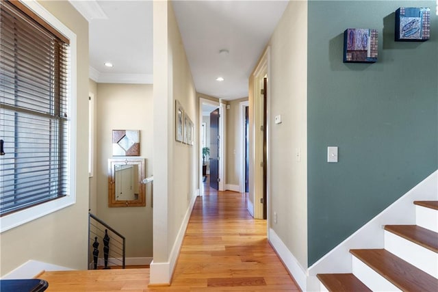 corridor with ornamental molding and light wood-type flooring