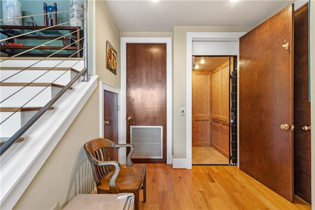 hallway with light hardwood / wood-style floors