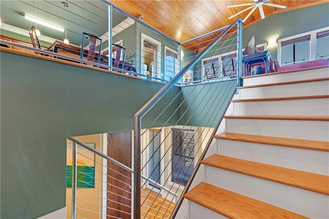 staircase featuring ceiling fan and wooden ceiling