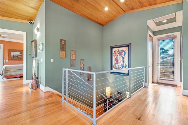 hall featuring high vaulted ceiling, ornamental molding, wooden ceiling, and hardwood / wood-style floors