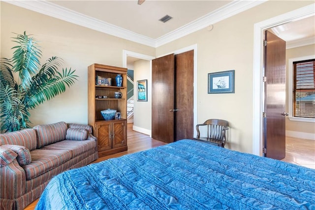 bedroom with ornamental molding and hardwood / wood-style floors