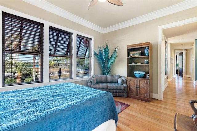 bedroom featuring multiple windows, wood-type flooring, ornamental molding, and ceiling fan