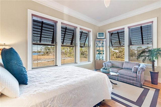 bedroom with ornamental molding and hardwood / wood-style flooring