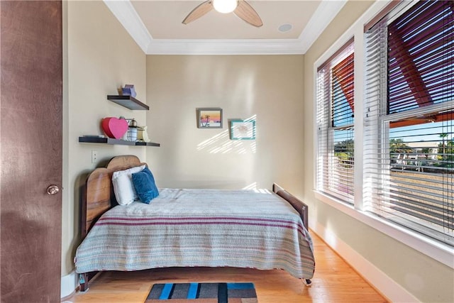 bedroom featuring crown molding, light hardwood / wood-style floors, and ceiling fan