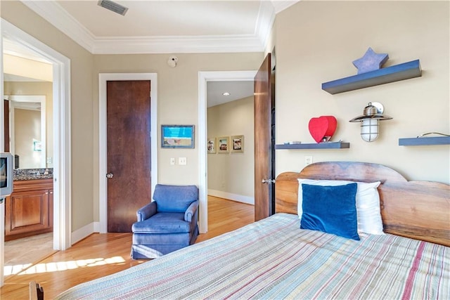 bedroom featuring ornamental molding, connected bathroom, and light hardwood / wood-style floors