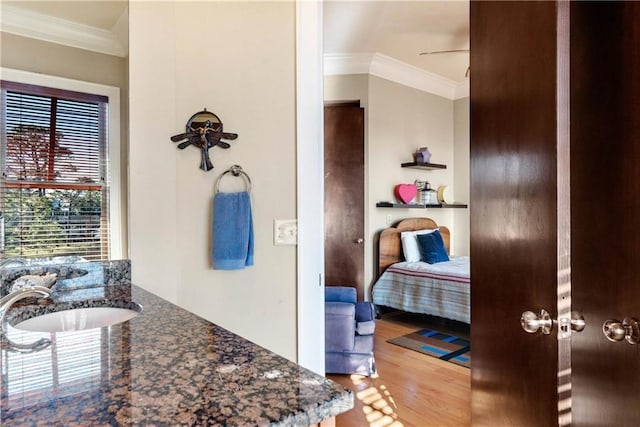 bedroom with wood-type flooring, ornamental molding, sink, and ceiling fan