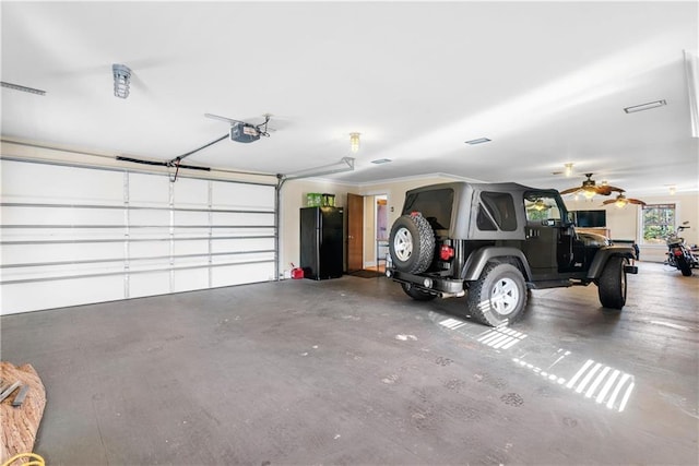 garage with a garage door opener, black refrigerator, and ceiling fan