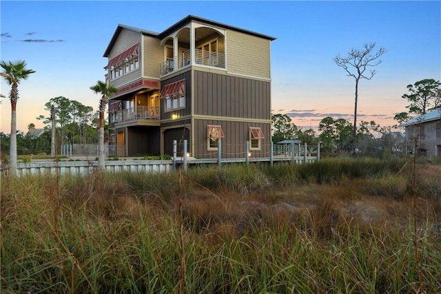 back house at dusk with a balcony