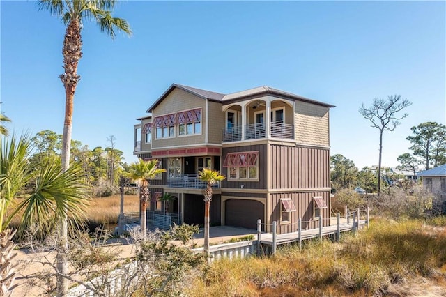 back of property featuring a balcony and a garage