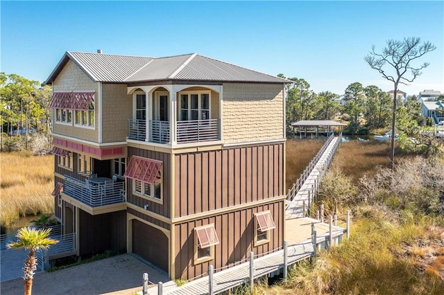 rear view of house featuring a balcony and a garage