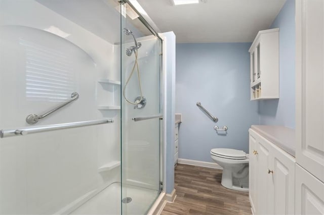 4221 Bay Front Rd, Mobile, AL 36605 - bathroom featuring toilet, a stall shower, wood finished floors, vanity, and baseboards