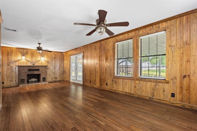 4221 Bay Front Rd, Mobile, AL 36605 - unfurnished living room featuring a ceiling fan, wooden walls, wood-type flooring, crown molding, and a brick fireplace