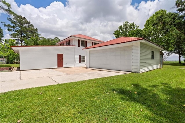 4221 Bay Front Rd, Mobile, AL 36605 - view of front of house featuring a garage, an outbuilding, a front lawn, and metal roof
