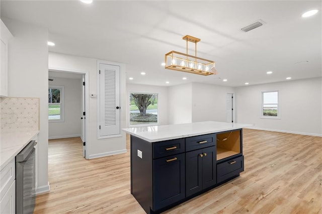 kitchen featuring black dishwasher, pendant lighting, light countertops, and a center island