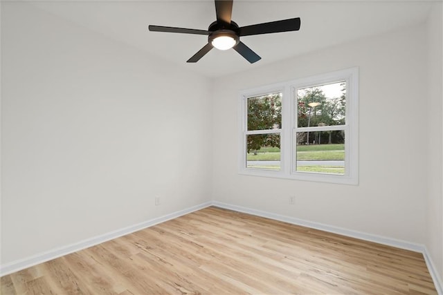 empty room featuring light wood finished floors, a ceiling fan, and baseboards