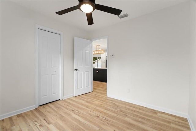 unfurnished bedroom with light wood-type flooring, visible vents, baseboards, and a ceiling fan