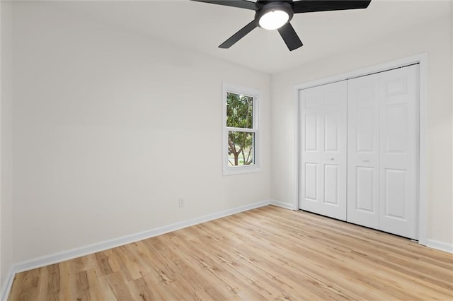 unfurnished bedroom featuring light wood-style flooring, baseboards, ceiling fan, and a closet