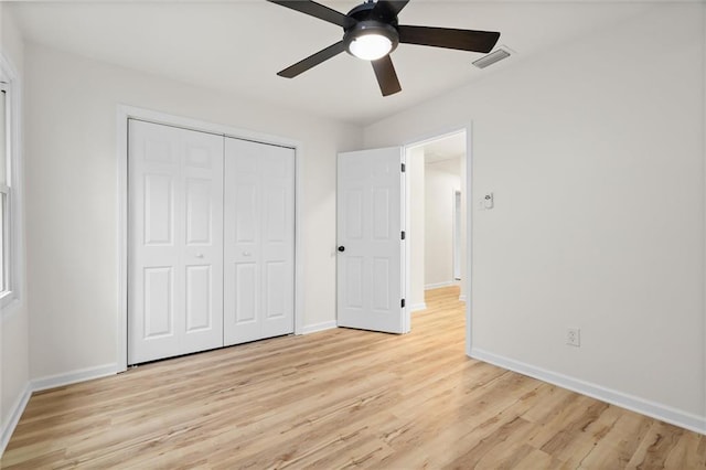 unfurnished bedroom featuring light wood-style flooring, a closet, visible vents, and baseboards