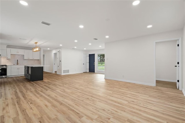 unfurnished living room with light wood-type flooring, visible vents, and recessed lighting